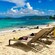 3 lounge chairs on the shore of a sandy beach